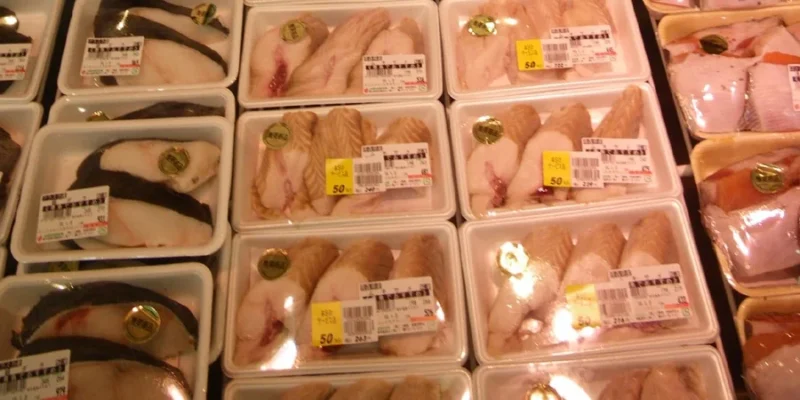 Refrigerated display case with packaged shark meat in the supermarket