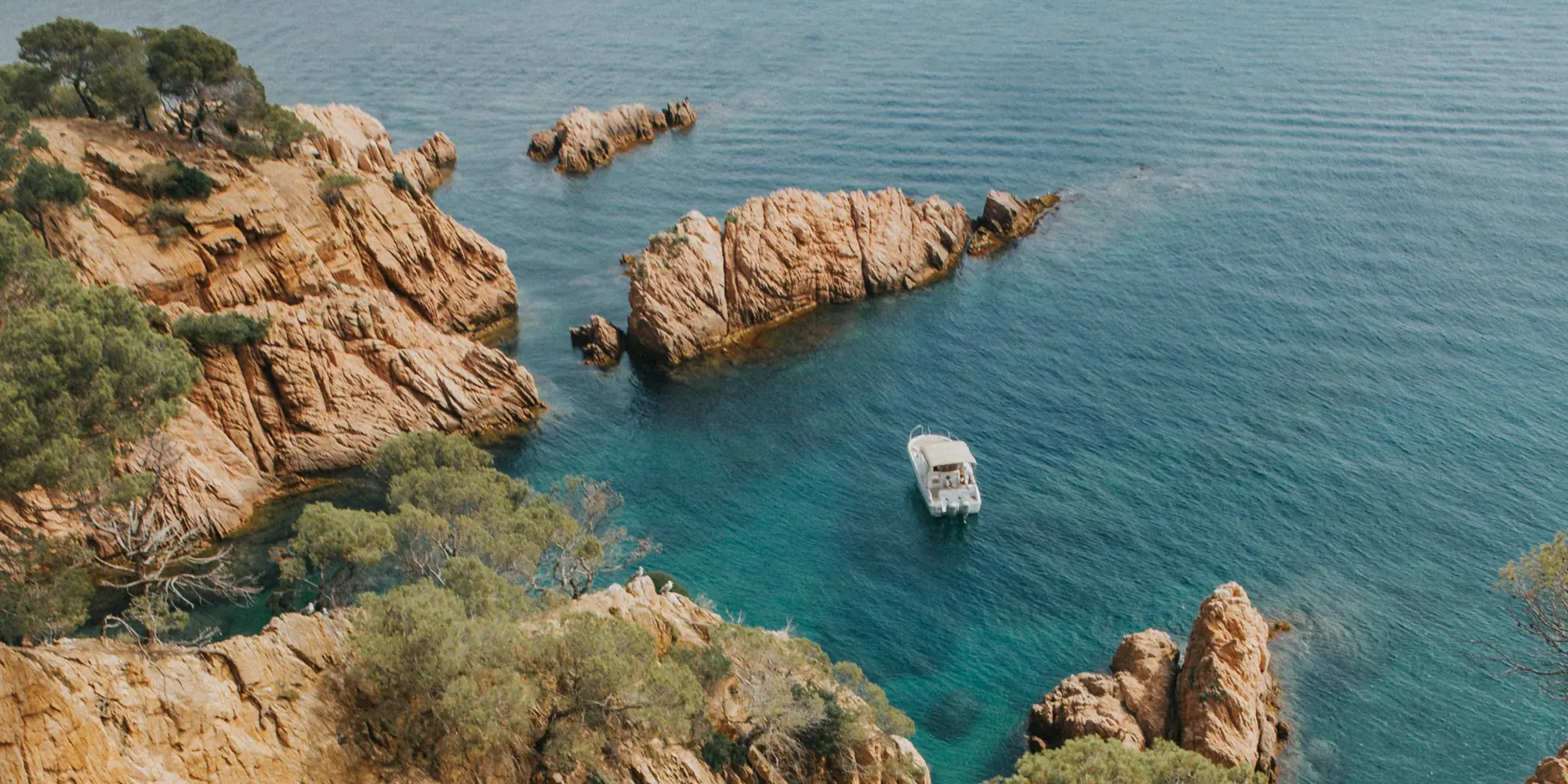 Diving with sharks in Spain rocky coast with boat in the sea