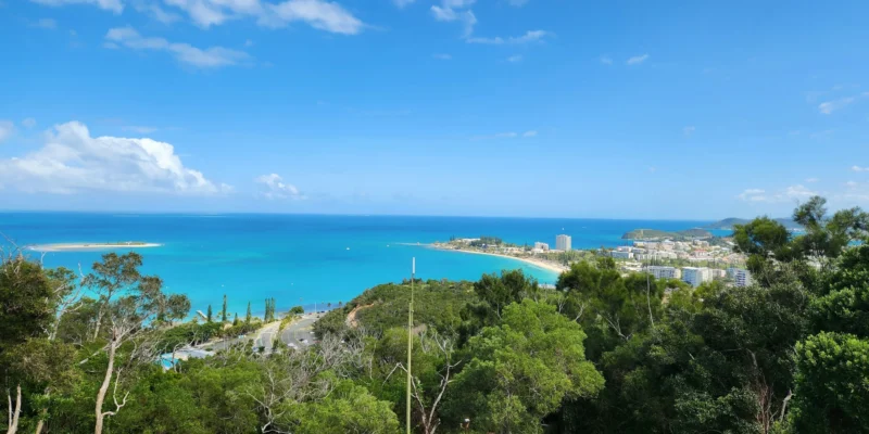 View from a wooded hill across the turquoise bay and the city of Nouméa